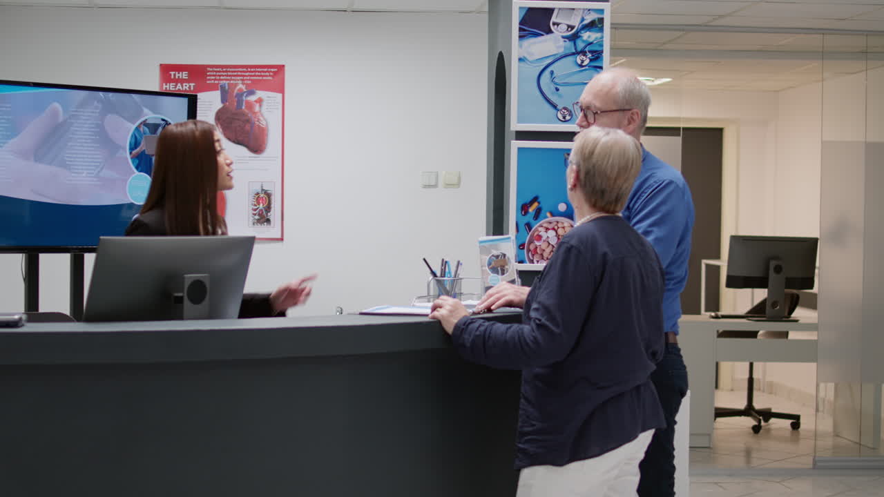 Hospital reception area with patients and medical receptionist