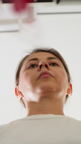 la mujer cambia de modo en el panel de control de la cinta de correr en el gimnasio. la señora seria amplía la velocidad de la máquina de entrenamiento para correr en el club deportivo de bajo ángulo. fuerza corporal