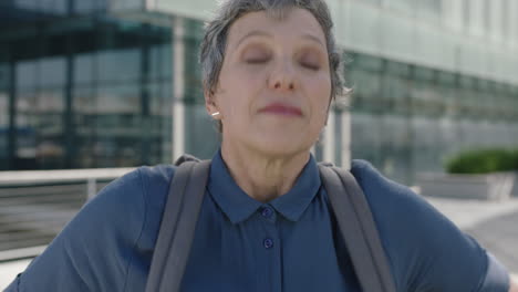 retrato de una mujer de negocios profesional madura que deja el trabajo con una mochila sonriendo feliz disfrutando de los desplazamientos urbanos