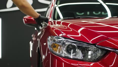 trabajador de servicio de automóviles aplicando nano recubrimiento en un detalle de automóvil.