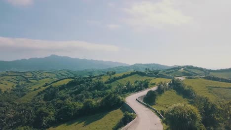 cinematic aerial drone video of a roadline into a picturesque mountain view of batanes in the philippines