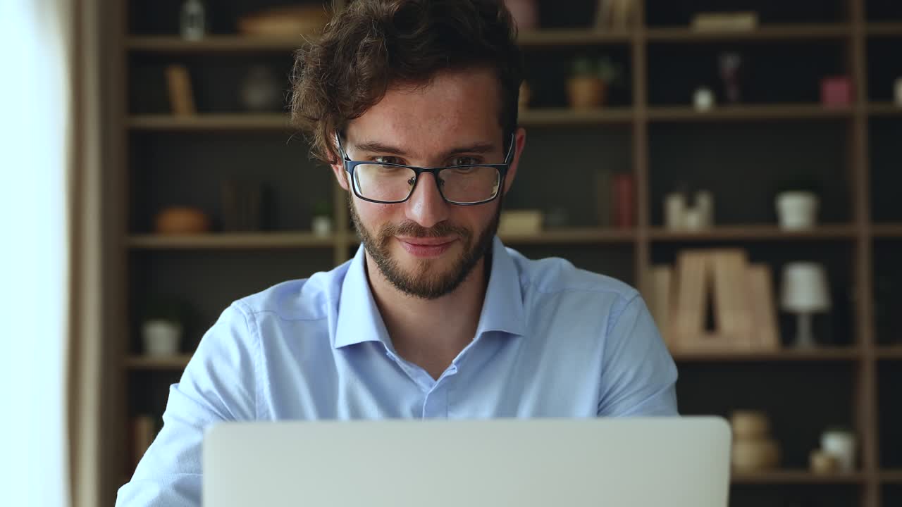 concentrado hombre milenario sentado frente a la pantalla de la computadora portátil ocupado en el trabajo