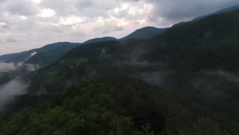 aerial view flying above lush green tropical rain forest mountain with rain cloud cover during the rainy season on the doi phuka mountain reserved national park the northern thailand