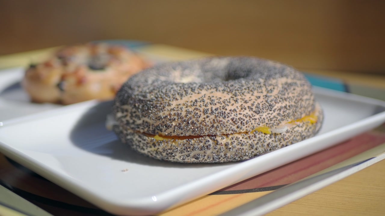 Close-up of a Poppy Seed Bagel Sandwich on a White Plate