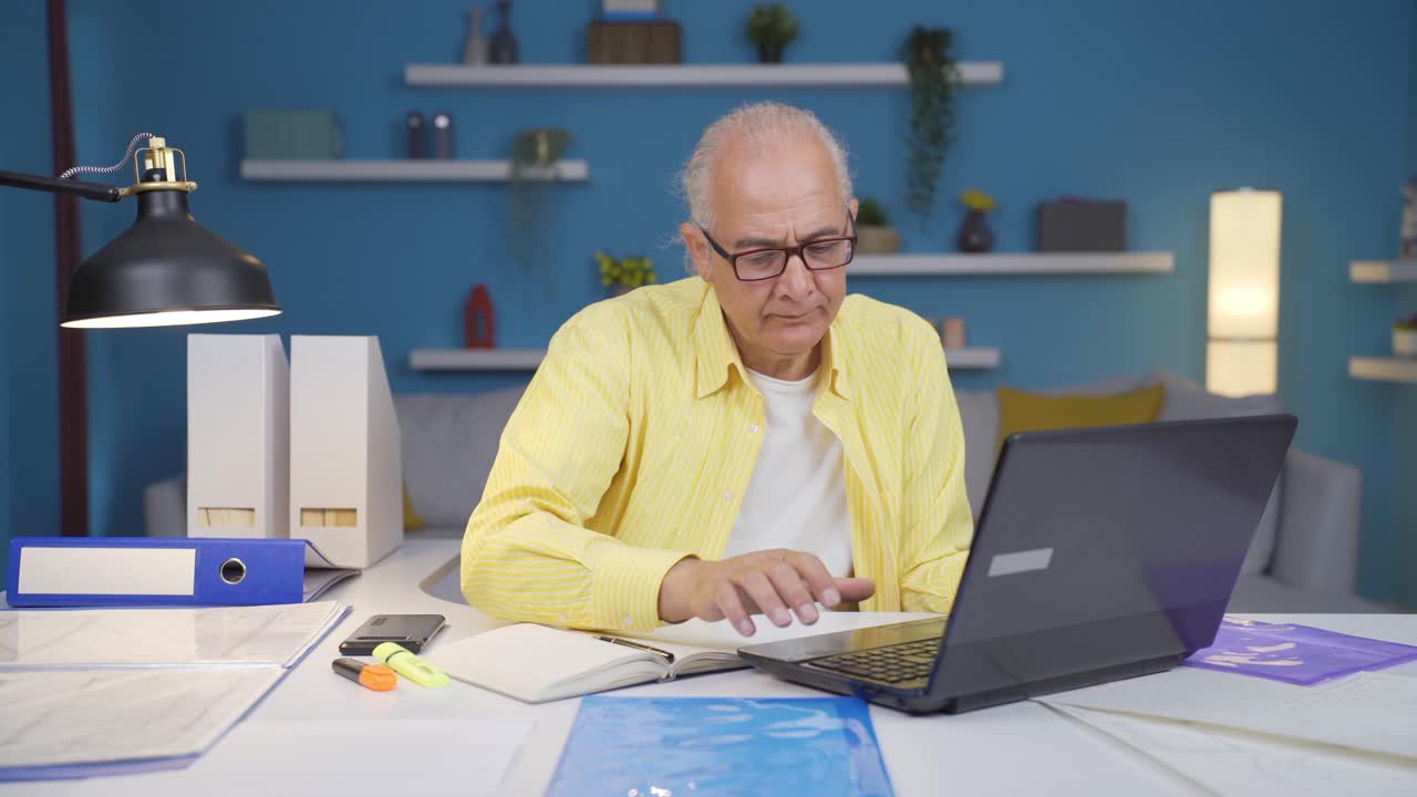 Home office worker old man smiling at camera.