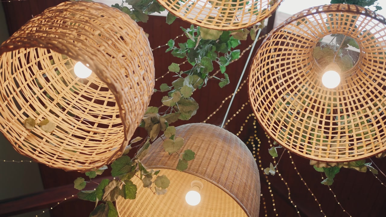 Rustic wicker lamps with vines and warm lights in festive event decor