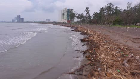 Verschmutzter-Verseuchter-Müll-Antenne-Strand-Küstenlinie-Vorwärts-Bewölkter-Tag