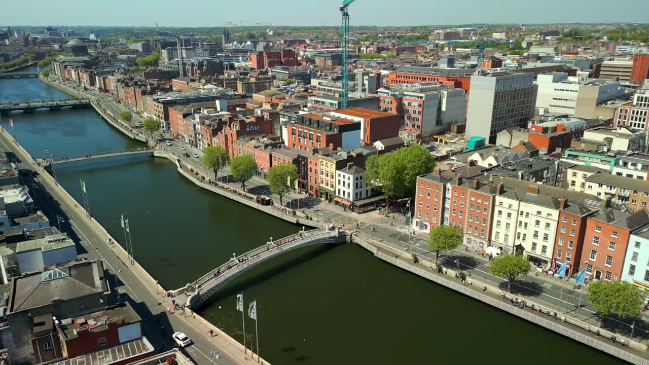 Side-on aerial of the River Liffey and the Dublin bridges in Dublin City Centre, Leinster, Ireland on a bright and sunny day. Filmed in 4K, 60FPS and with Rec709 color.
