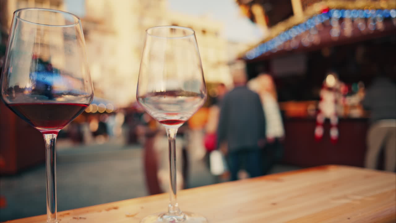 Close up of two glasses of red wine standing on the table at the Cannes Christmas Market with a blurry background