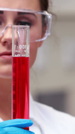 científico mirando el vaso de productos químicos