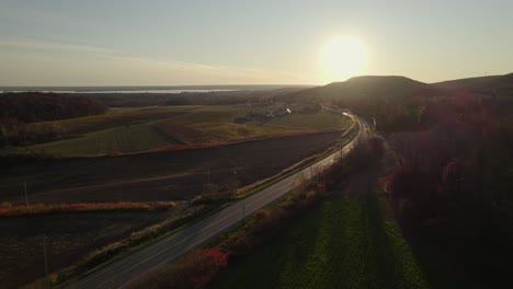 Farmhouse-near-a-long-road-at-sunset