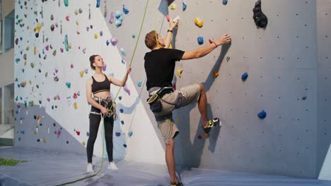 personas escalando roca en una pared de escalada interior