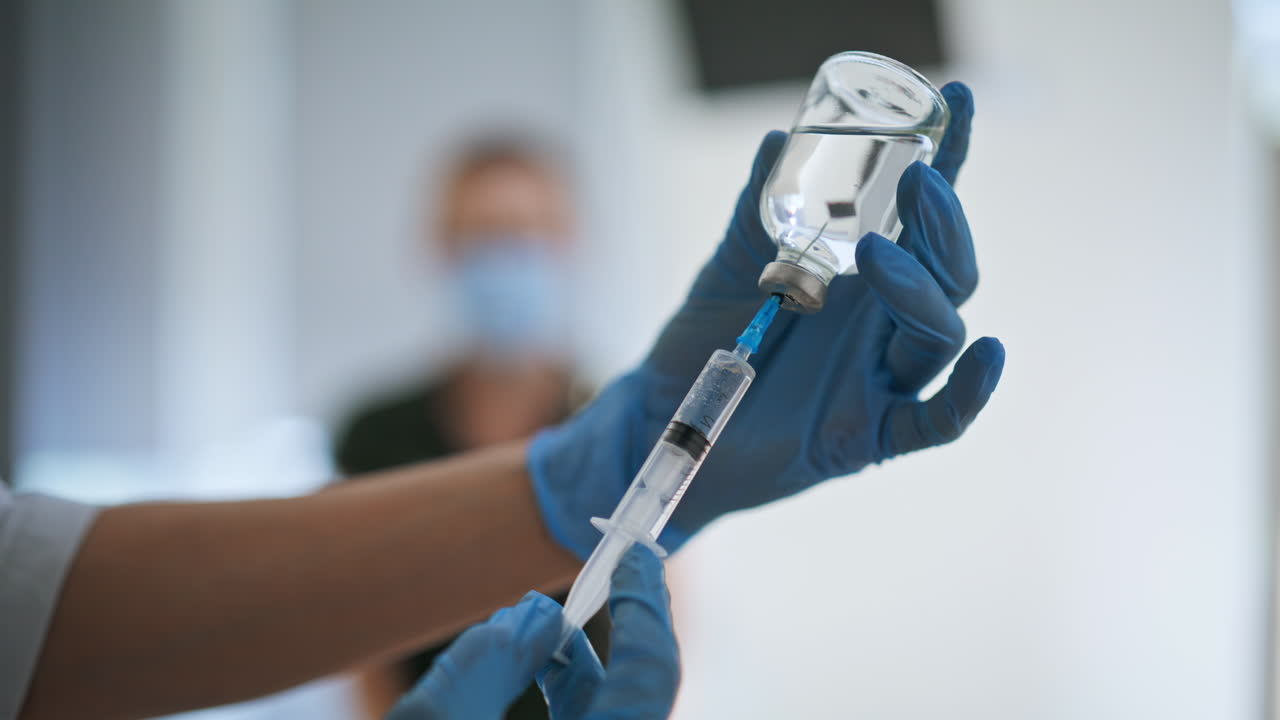 Doctor hands taking vaccine holding medical syringe injecting in woman closeup