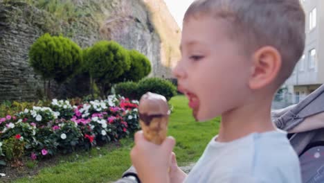 portrait of caucasian boy eating and enjoying ice cream, face smeared with chocolate ice cream