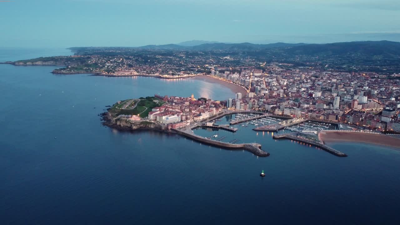 무인 항공기는 스페인의 기혼시 상공을 비행하며 도심 교통 바다 바다 모래 해변과 항구, 갈리시아 지역의 주요 도시의 공중 전망으로 밤에 조명을 비춥니다.