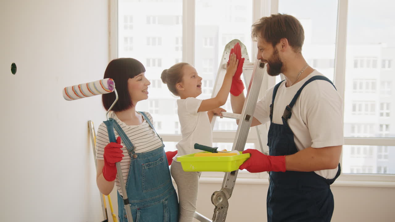 가족이 함께 벽을 칠합니다.