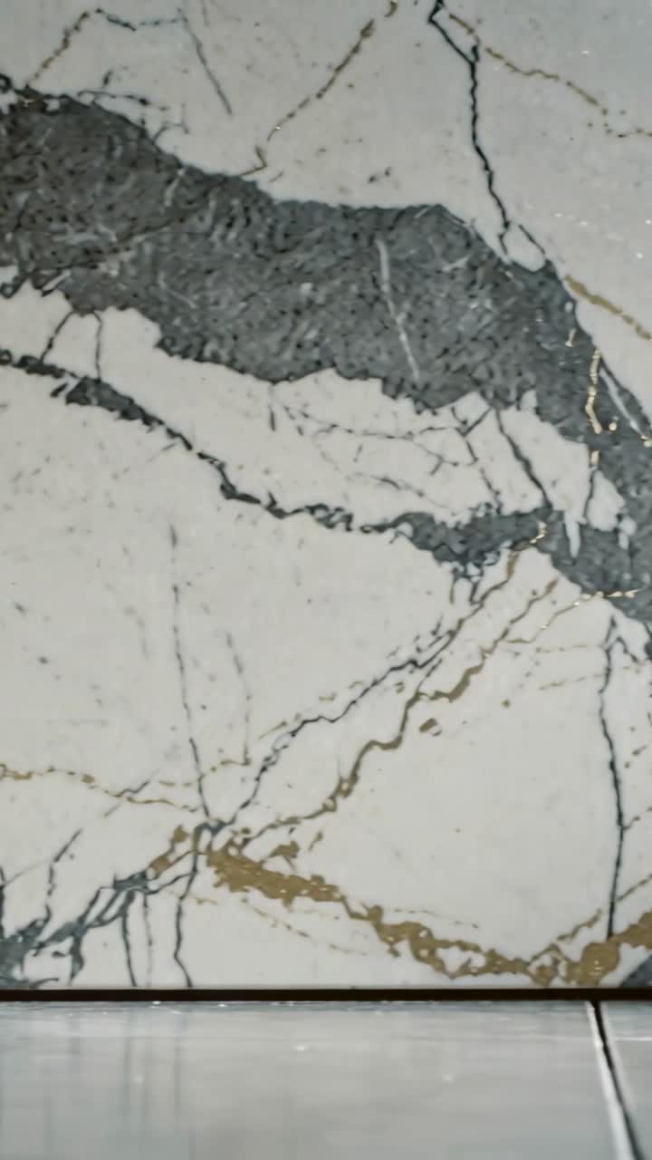 Video verticale: Telecamera che si inclina rivelando un pannello murale in marmo nella hall, mostrando una fascia scura e il pavimento