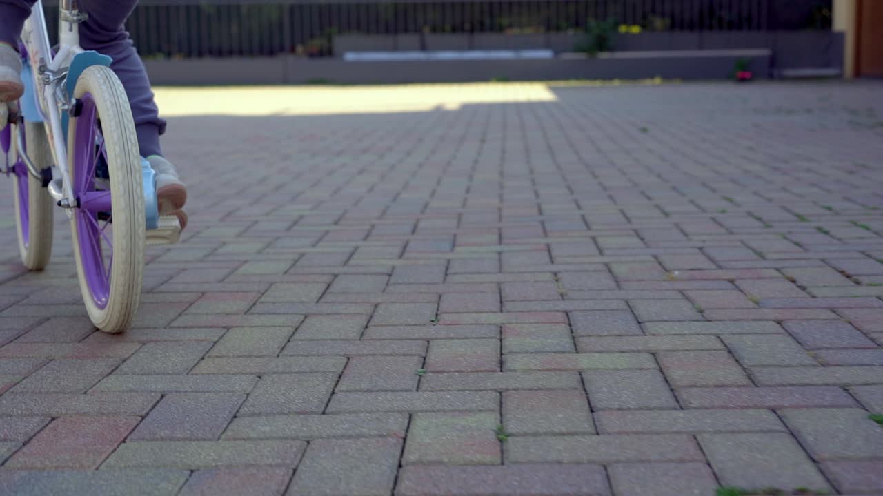 뒤뜰에서 보라색 자전거를 타는 어린 아이의 슬로우 모션