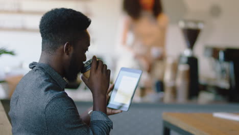 african american businessman using tablet computer in cafe drinking coffee watching online entertainment stylish entrepreneur reading social media messages enjoying internet connection