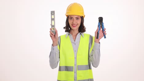 female construction worker holding spirit level and pliers