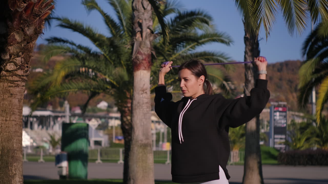 mujer haciendo ejercicio al aire libre con banda de resistencia