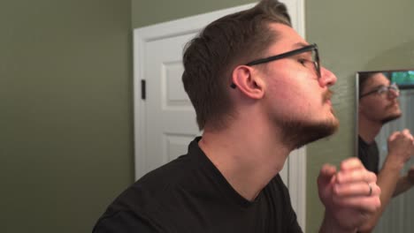 hombre con gafas recorta su barba hasta una barba de cabra con un cortador eléctrico