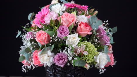 Flower-basket-bouquet-gerbera-and-roses-spinning-in-black-background