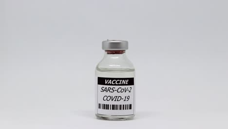 single vial bottle of coronavirus vaccine in white background - dolly out, studio shot