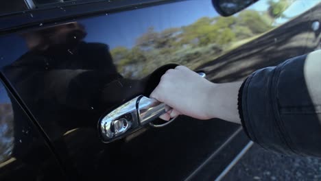 masked man trying to jam the car handle and force to open the door