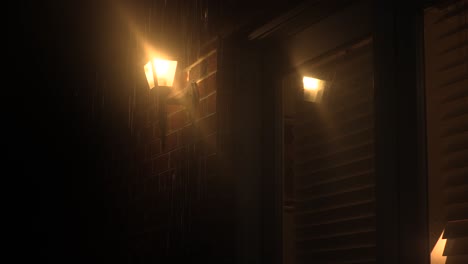 house lamp illuminating a glass door in the rain