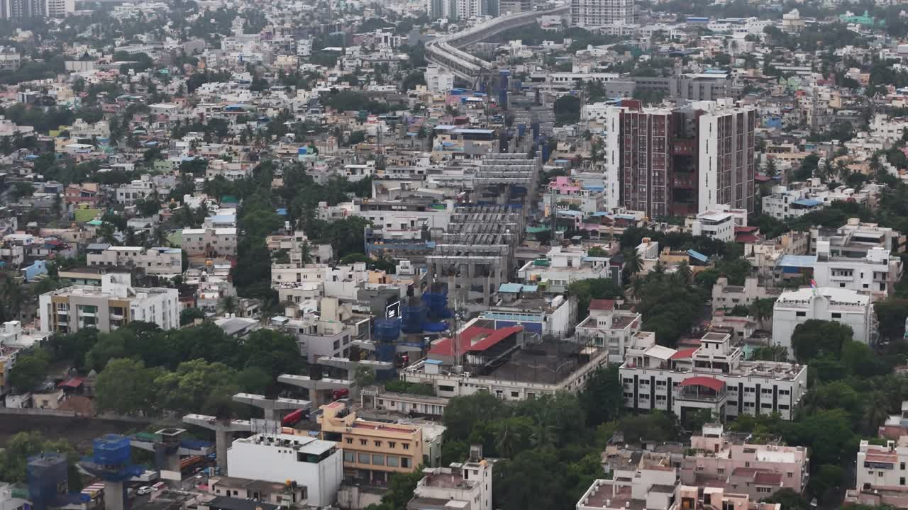 Infrastrutture e trasporti: linee sopraelevate della metropolitana, un grande deposito ferroviario e vari cantieri edili con gru, perfetti per mostrare la pianificazione e la crescita della città