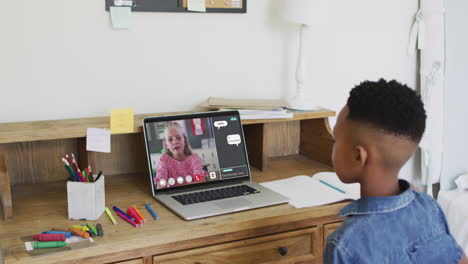 african american boy raising his hands while having a video call on laptop at home