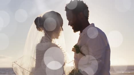 Animation-of-dots-over-happy-african-american-newly-married-couple-on-beach