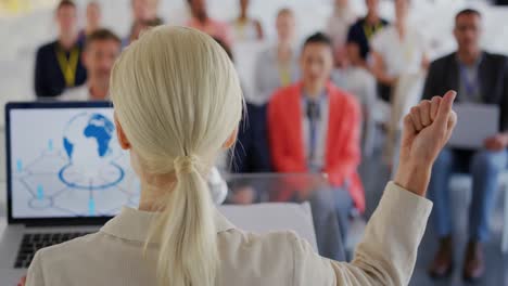 female speaker adressing the audience at a business conference