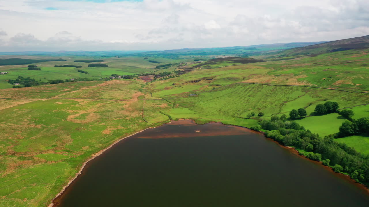밝고 화창한 날, 녹색 농지로 둘러싸인 여전히 호수를 보여주는 공중 풍경 사진