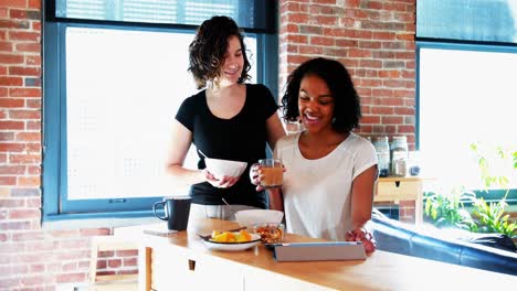 pareja de lesbianas interactuando entre sí mientras desayunan