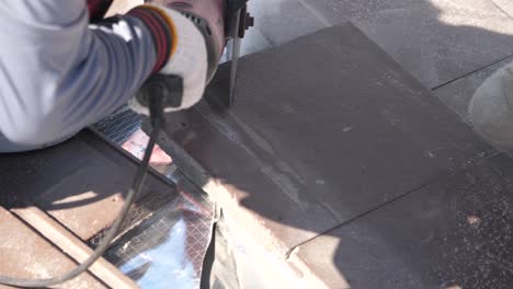 asian worker doing roof tiles installation, cutting, measuring process, close up