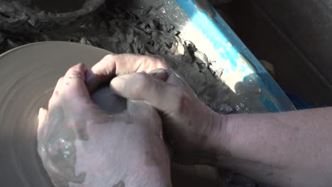 potter's hands making a bowl