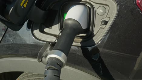 electric ev charge cable plugged into car socket close up shot