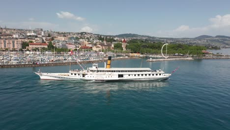 aerial of beautiful old cruise ship leaving harbor with a city in the background