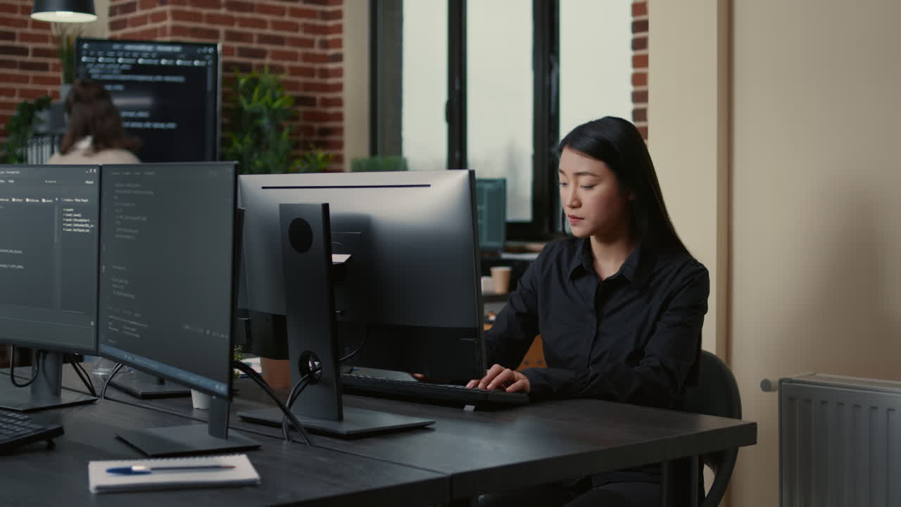 Portrait of asian programer focused on writing code sitting at desk