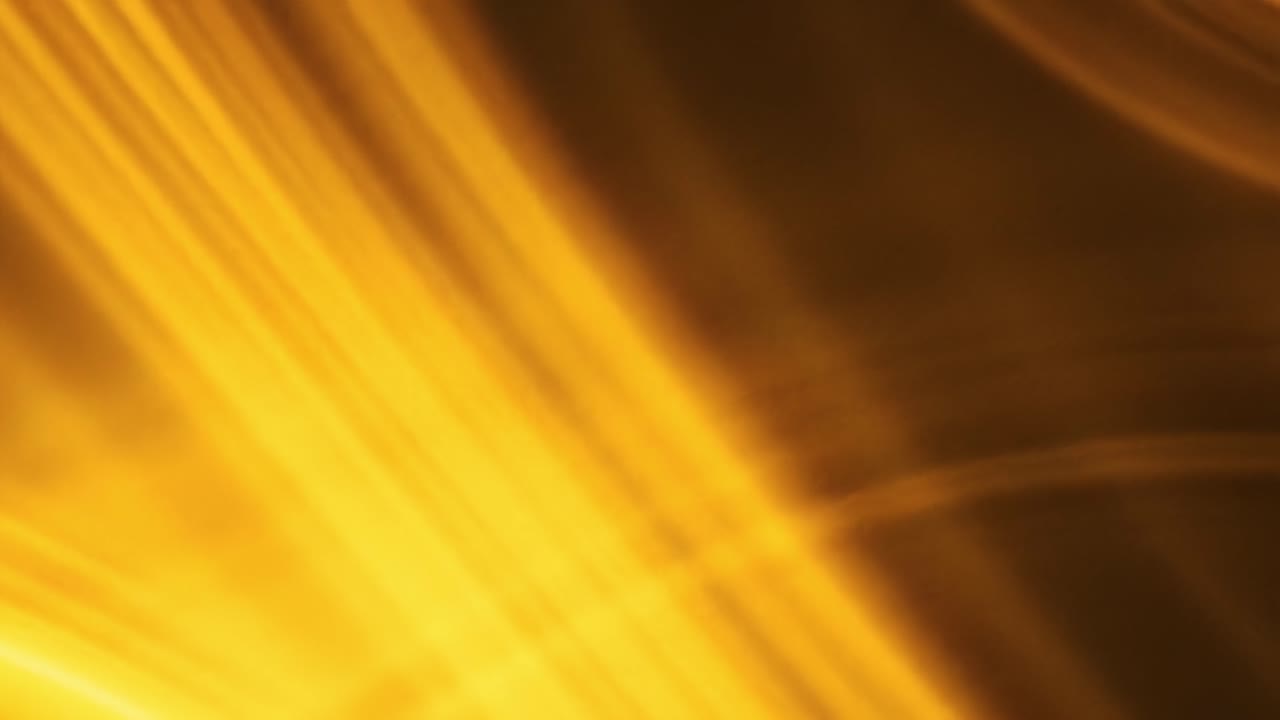 Bright golden hues swirl and flow elegantly, creating mesmerizing abstract patterns. The dynamic motion captivates, showcasing a blend of light and color that enchants viewers.