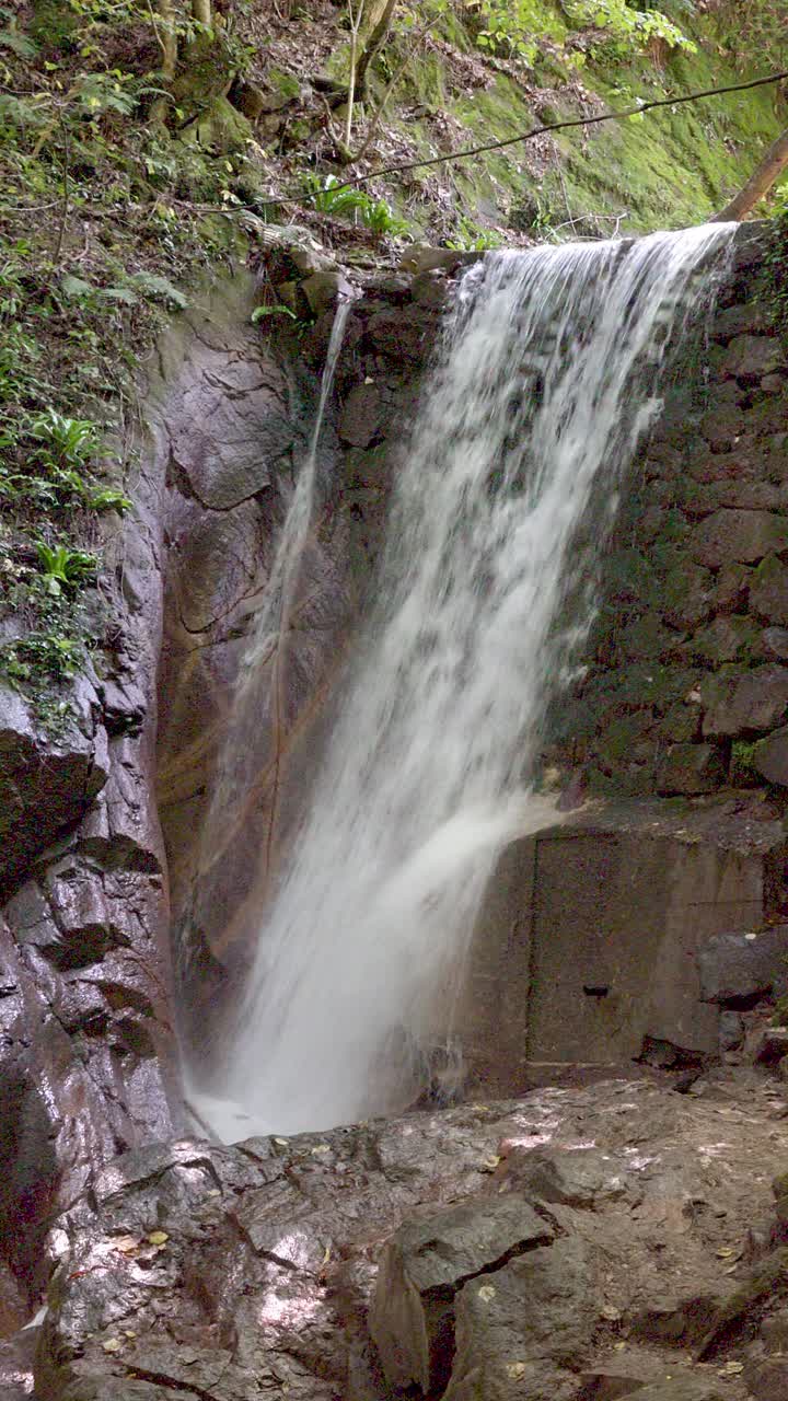 Closeup of a man-made waterfall surrounded by nature near the Rastenbachklamm gore above Kaltern - Caldaro, South Tyrol, Italy