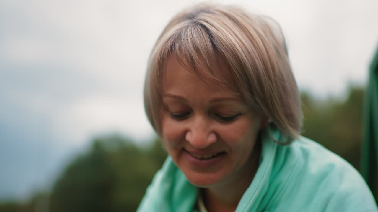 dog tamer wearing blue jacket smiling warmly outdoors under cloudy sky showing happiness and calm energy highlighting emotional connection and love for animals during relaxed natural moment