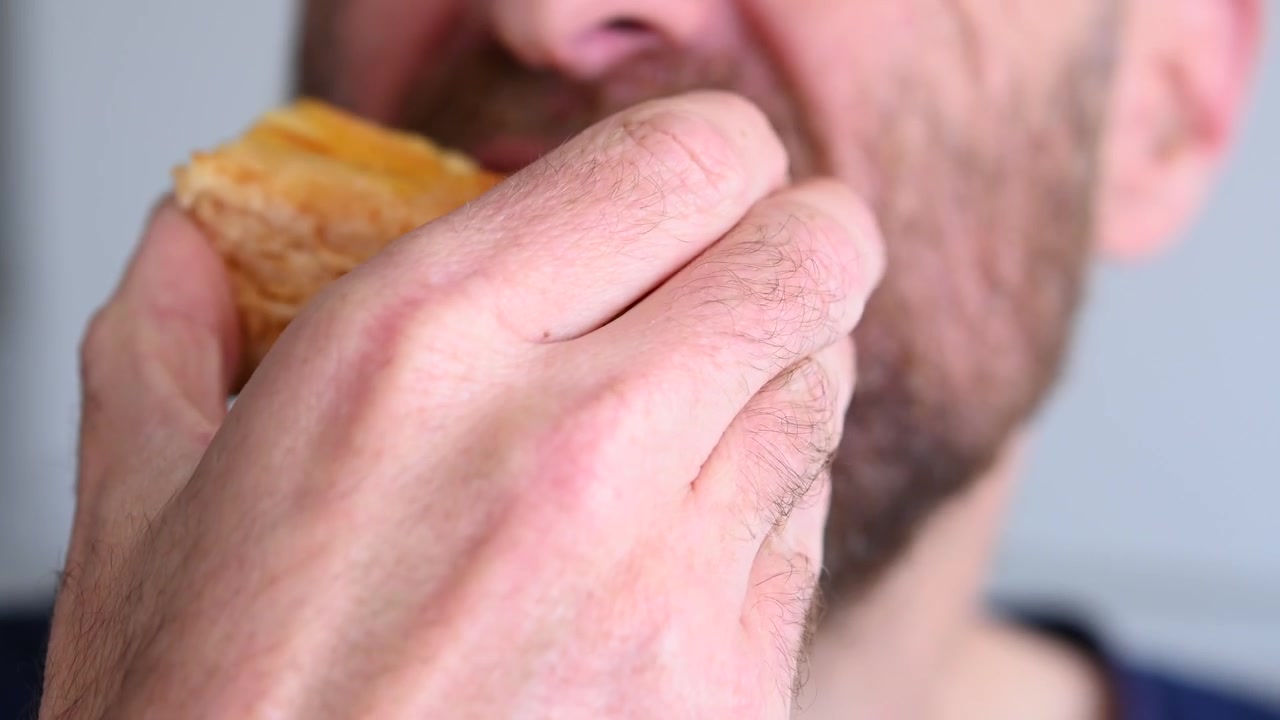 Bearded man eating apple pie at home