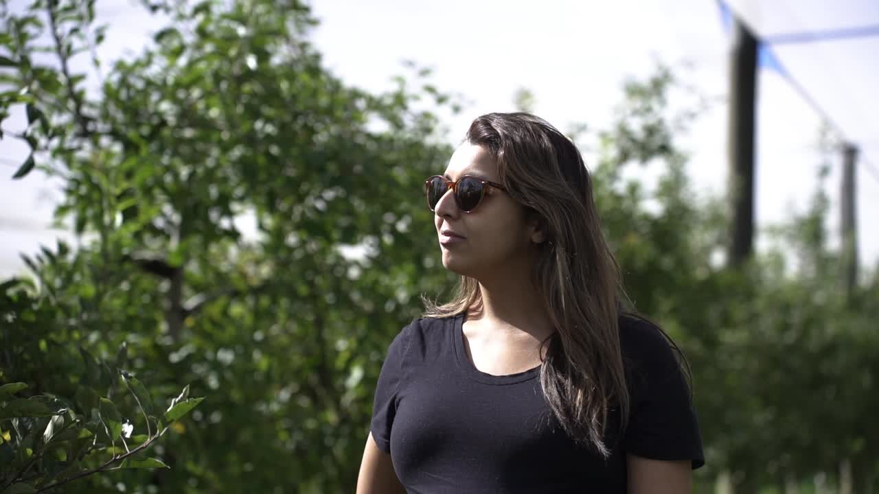 hermosa mujer del sur de asia caminando por una granja de frutas en verano - de cerca