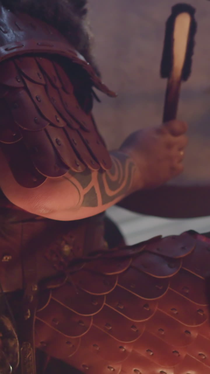 Performer plays old leather shamanic drum with special furry stick at concert in old cabin closeup. Musician plays ritual music. Folk band