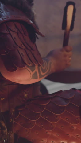 performer plays old leather shamanic drum with special furry stick at concert in old cabin closeup. musician plays ritual music. folk band