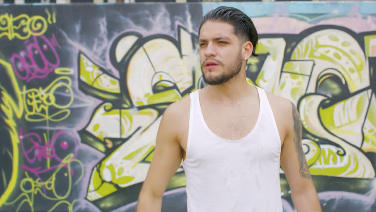 스케이트 공원에 있는 플라스틱 병에서 신선한 물을 마시는 잘생긴 남자