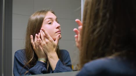 Una-Mujer-Caucásica-Examina-Su-Piel-Perfecta-En-El-Espejo.